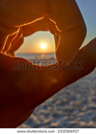 A picture of the sun in the hands of a person 