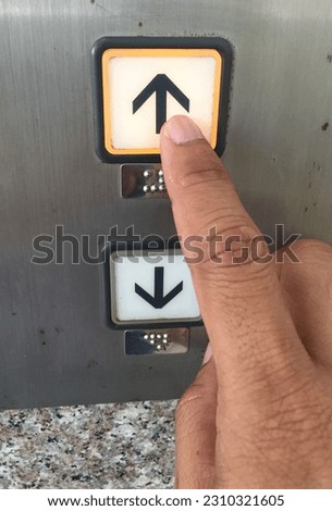 hand pushing elevator button up