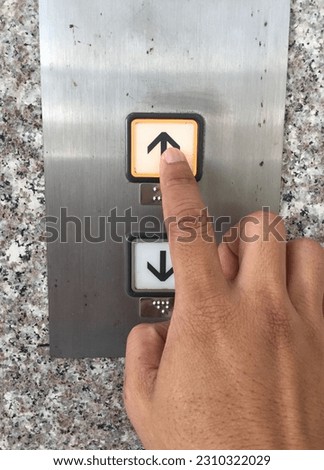 hand pushing elevator button up