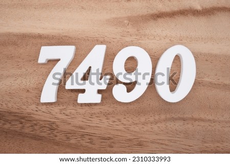 White number 7490 on a brown and light brown wooden background.