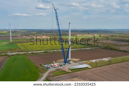 Construction of a wind turbine with a blue crawler crane Royalty-Free Stock Photo #2310335425