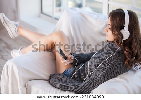  Attractive young woman listening music with earphone
