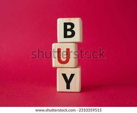 BUY symbol. Concept word BUY on wooden blocks. Beautiful red background. Business and BUY concept. Copy space