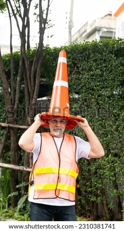 Engineer senior man with traffic cone on head. funny under construction