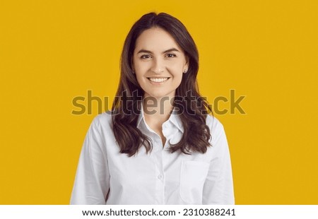 Profile picture studio headshot of business manager or company website consultant. Portrait smiling beautiful young woman in white shirt with perfect teeth isolated on bright yellow colour background