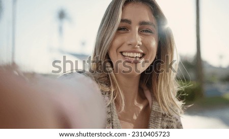 Young blonde woman smiling confident making selfie by camera at street