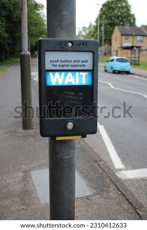 Pedestrian crossing control panel with text "Push button and wait for signal opposite" WAIT text illuminated