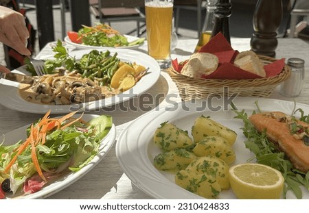 two dishes with fish, meat and salad on the table Royalty-Free Stock Photo #2310424833