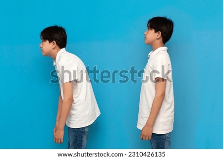 concept of bad posture, boy of twelve years old stoop on blue isolated background, comparison of bad and good posture, problem with the back and spine of child Royalty-Free Stock Photo #2310426135