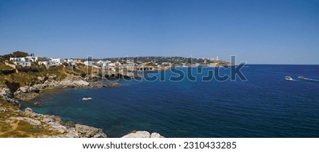 Panoramic view of the cape of Santa Maria di Leuca and its lighthouse in Puglia, Italy. Rocky coast, its caves and the white architecture of its houses at the foot of the Ionian Sea on a sunny summer  Royalty-Free Stock Photo #2310433285