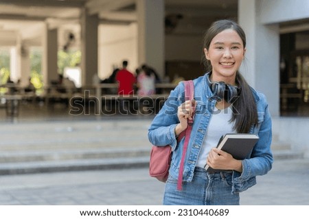 Beautiful student asian woman with backpack and books outdoor. Smile girl happy carrying a lot of book in college campus. Portrait female on international Asia University. Education, study, school

