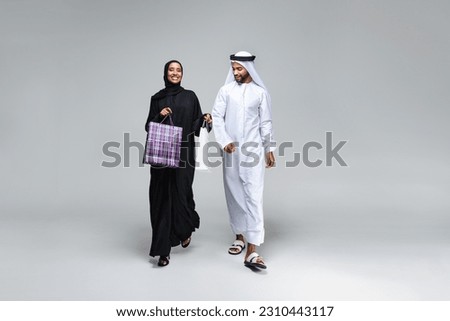 Beautiful arab middle-eastern happy couple of lovers wearing traditional abaya and kandora in studio - Arabic muslim adult people bonding and having fun in Dubai, United Arab Emirates Royalty-Free Stock Photo #2310443117
