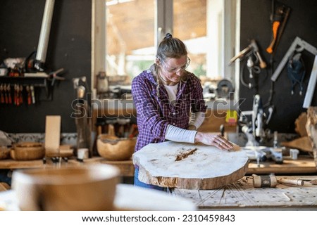Craftswoman working with wood in carpentry workshop
