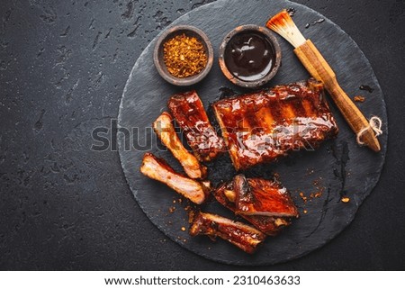 Barbecue pork spare ribs with hot honey chili marinade on black background Royalty-Free Stock Photo #2310463633