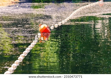 Barrage buoys on an abandoned green lake