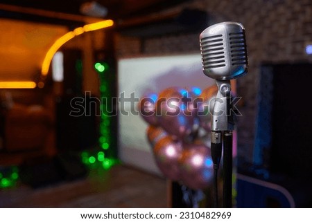 Retro Microphones on front stage in pub bar or restaurant. Classic sing a song in evening and night show concert light bokeh background.