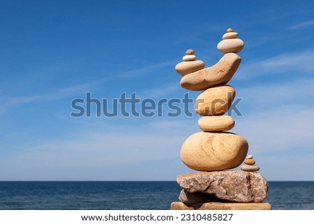Rock zen pyramid of yellow stones on the beach. Concept of Life balance, harmony and meditation Royalty-Free Stock Photo #2310485827