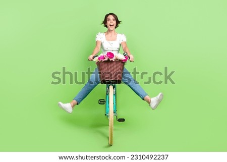 Full length photo of excited funky woman dressed white top riding bicycle isolated green color background