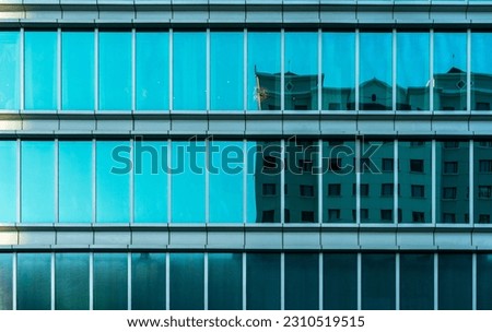 Blue office building seen from a distance with many glass windows 8k Royalty-Free Stock Photo #2310519515