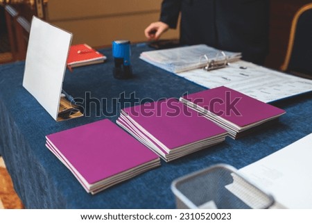 Gift bag package for conference participants before start, with a leaflet handout, notebook notepad, mug, pen, pencil, corporate gifts and souvenirs for employees of the company, office gift giving Royalty-Free Stock Photo #2310520023