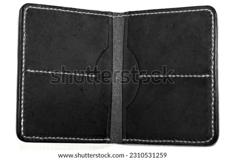 Top view of New black genuine leather wallet isolated on white background.