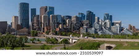 Panoramic city skyline in Calgary, Alberta during summer time with beautiful blue sky day Centre St Bridge in view.  Royalty-Free Stock Photo #2310539097