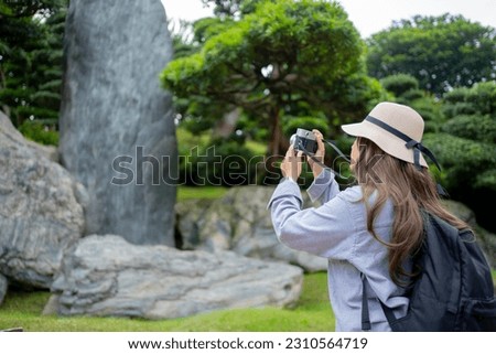 Asian tourist, cute woman with long hair are traveling in Hong Kong along with map and her camera with fun on her holiday, A temple in Hong Kong, concept travel.