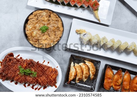 A top down view of several Japanese appetizers and entrees.