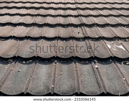 Full frame image of housetop with  red and brown roofing tiles on a sunny day