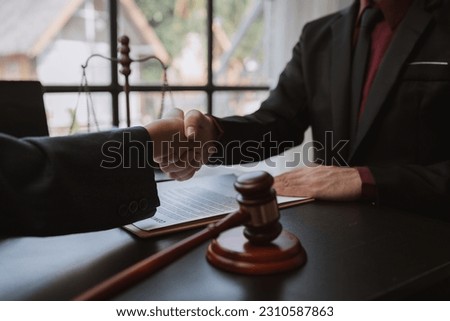 Businessmen shaking hands to sign agreement with lawyer or legal adviser and partner to discuss agreement and signing business venture agreement.