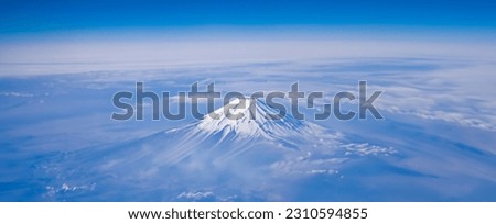 Top view of the Japan icon Mt Fuji from the airplane. Mt. Fuji seen from the window of an airplane. bird eye view of fuji mountain, famous volcano in japan, shot from airplane window. Royalty-Free Stock Photo #2310594855