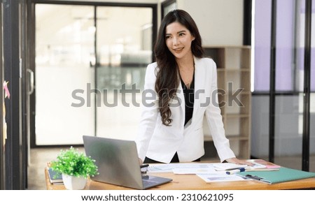 Businesswoman standing with her arms crossed and confidently looking at the camera in the office.