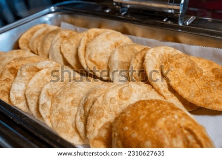 Luchi, a deep-fried flatbread made of wheat flour that is typical of Bengali cuisine. 
Traditional Puri (also called Luchi) in buffet breakfast at a hotel