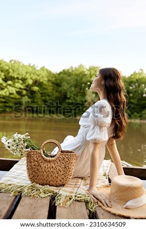 close up photo of a woman sitting by the lake with a wicker bag full of daisies