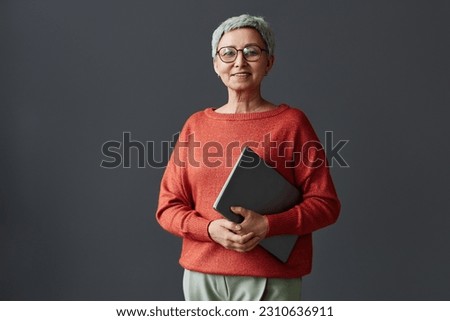 Minimal waist up portrait of smiling senior businesswoman looking at camera against wall, copy space Royalty-Free Stock Photo #2310636911