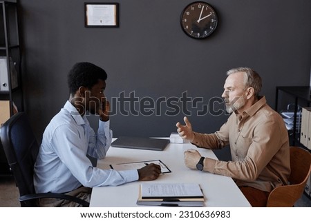 Side view portrait of bearded mature man talking to HR recruiter at job interview Royalty-Free Stock Photo #2310636983
