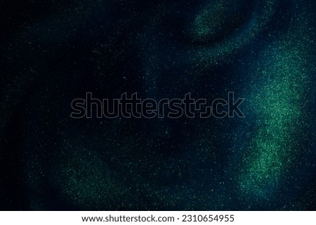 Shiny Dust Particles Galaxy in Blue Fluid With Green Tints. Gold Dust Particles Floating in a Blue Liquid. Abstract Magic Sparkling Background.