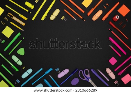 Rectangular frame of colorful rainbow school and office stationery set on black background. Top view, place for text.