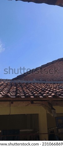 photo of an old building that is still strong and sturdy. above the roof visible sky is very beautiful and not