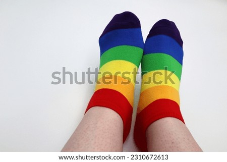 Feet with pride rainbow stripes socks gender revealing and equality public clothing wearable fabric textile on white background - LGBT community and culture