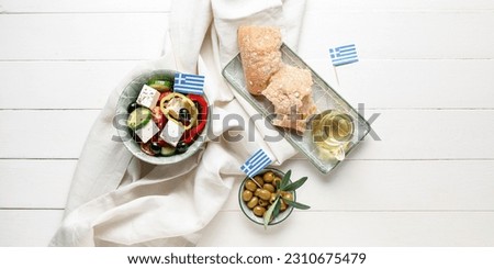 Traditional Greek salad, olives, oil and bread on white wooden background