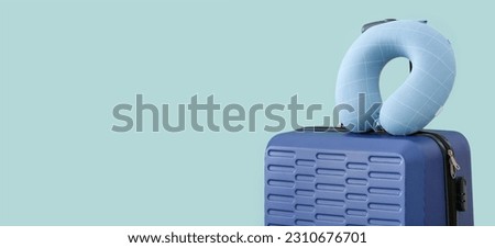 Packed suitcase and travel pillow on light blue background with space for text Royalty-Free Stock Photo #2310676701