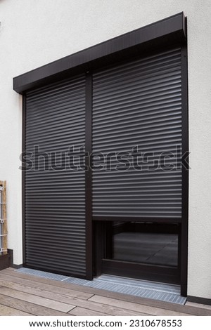 View of building with big windows and black roller shutters outdoors Royalty-Free Stock Photo #2310678553