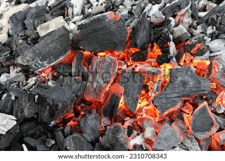 Many smoldering coals as background, closeup view