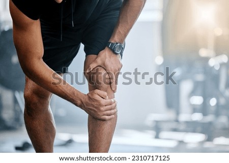 Fitness, gym and mockup, man with knee pain and medical emergency from workout injury at sports studio. Exercise, health and wellness, bodybuilder with hand on leg muscle ache for relief at training. Royalty-Free Stock Photo #2310717125