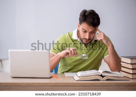 Young male student sitting in front of whiteboard