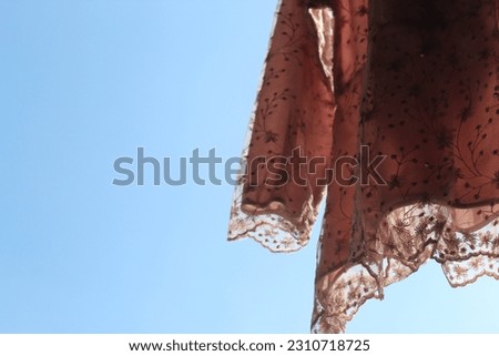 close up clothesline pink dress with a beautiful blue sky background suitable for backgrounds and creative editing materials and others