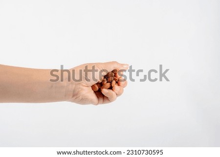 hand holding Almonds seed isolated on white background