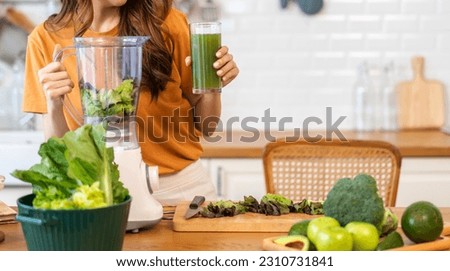 Portrait of beauty healthy asian woman making green vegetables detox clean and green fruit smoothie with blender.young girl drinking glass of green fruit smoothie in kitchen.Diet concept.healthy drink Royalty-Free Stock Photo #2310731841