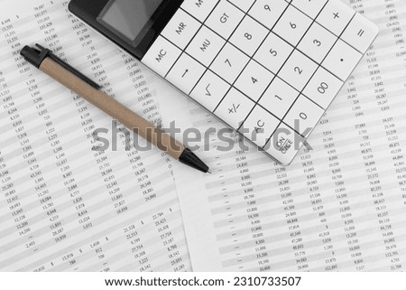 Calculator with pen on financial statement.